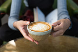 woman is holding cup of coffee