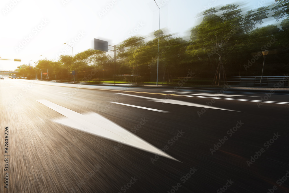 sunlight and empty asphalt road with traffic sign