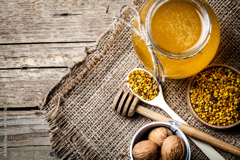 glass of fresh honey isolated and walnuts in a bucket glass of fresh honey isolated and walnuts in a bucket