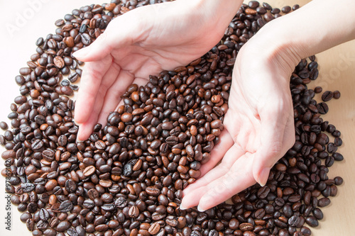 Fresh roasted organic Coffee beans in a woman hands on isolated background  food and drink background