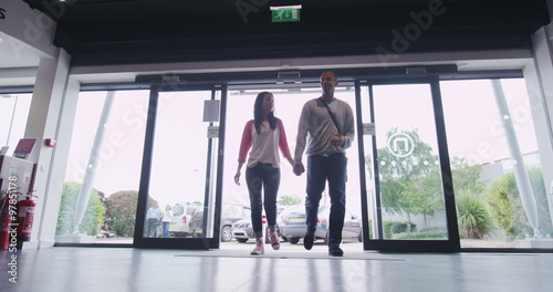 Couple entering large consumer electronics store showroom