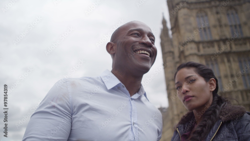 Happy attractive couple sightseeing in London taking a selfie in front of houses of parliament. Happy attractive couple sightseeing in London taking a selfie in front of houses of parliament.