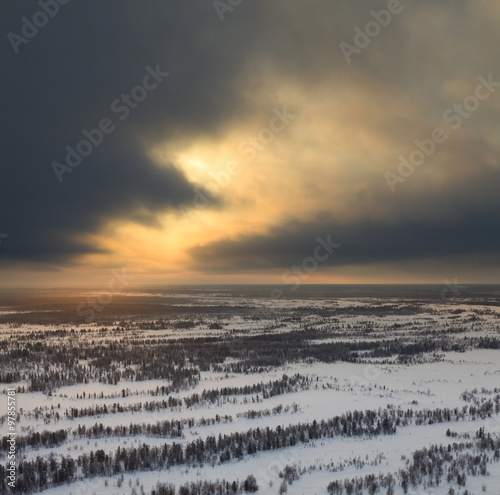Cloudy sunset above wooded plain, top view