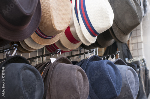 hats for sale hanging from a wall in Paris