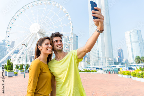 Caucasian couple take the selfie by sellphone at Hong Kong photo