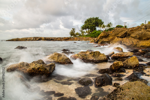 Sunset at Shark's Cove Beach with rocky shore photo