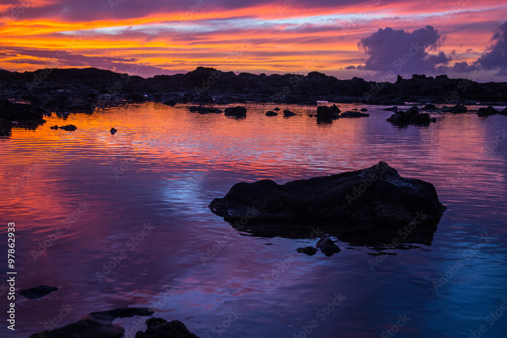 Sunset at Shark's Cove Beach with rocky shore