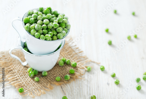 frozem peas on wooden surface photo