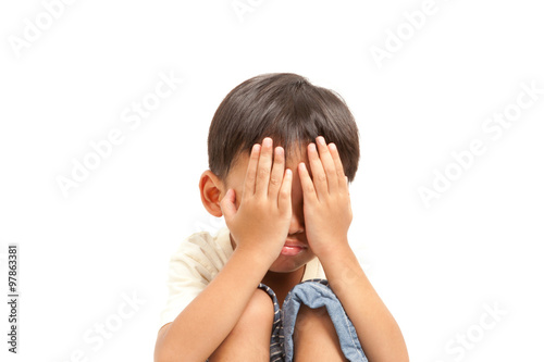 Angry sad crying child boy punishment with both hands cover his face,solated on white background