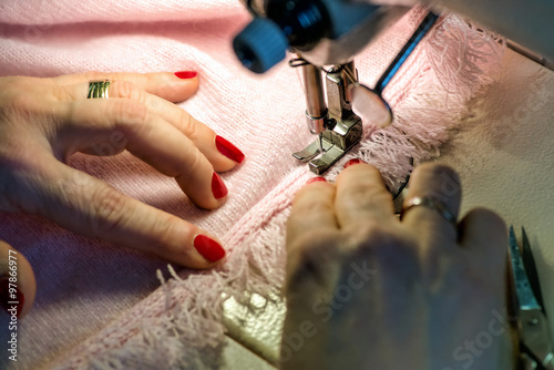 Female Hands Sewing Fringe on Pink Garment