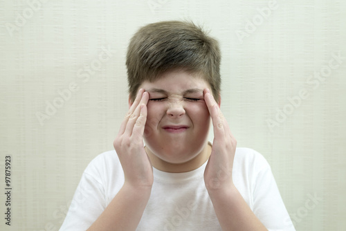 Portrait of  teenage boy with a headache photo