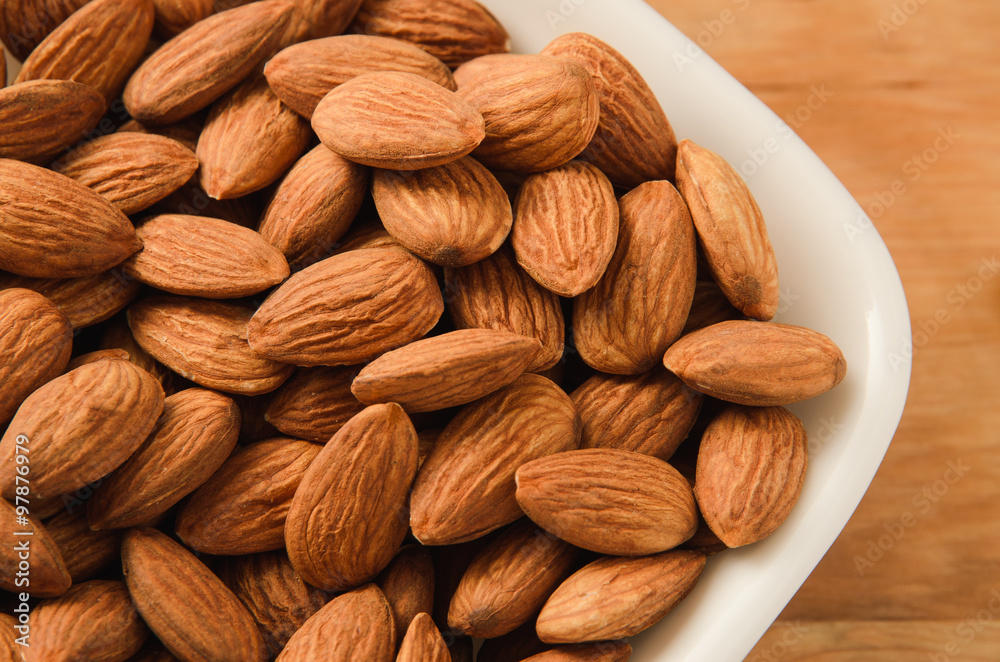 Healthy snack almond kernels in white bowl Healthy snack almond kernels in white bowl