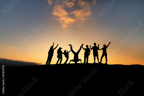 Happy group of people and beautiful sunset sky