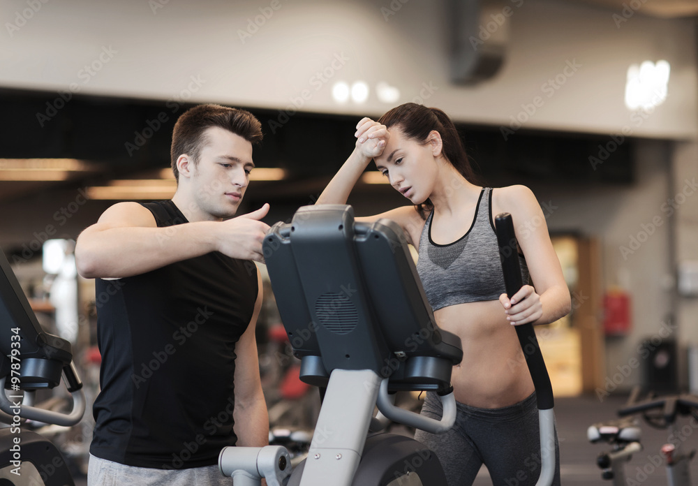 woman with trainer exercising on stepper in gym woman with trainer exercising on stepper in gym