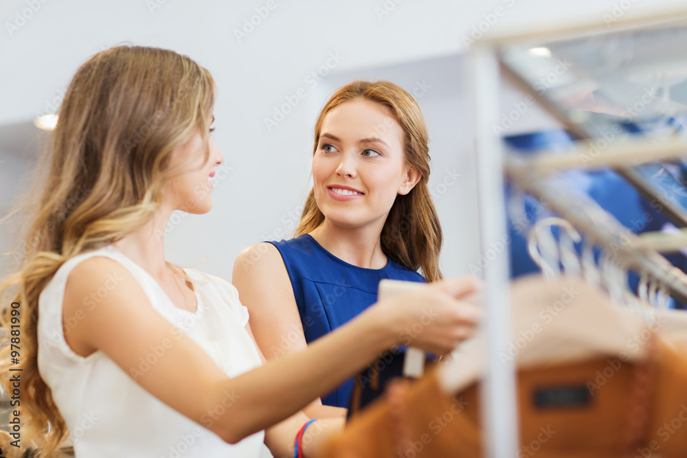 happy women with shopping bags at clothing shop happy women with shopping bags at clothing shop