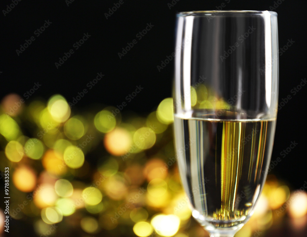 A glass of champagne with bokeh on dark background A glass of champagne with bokeh on dark background