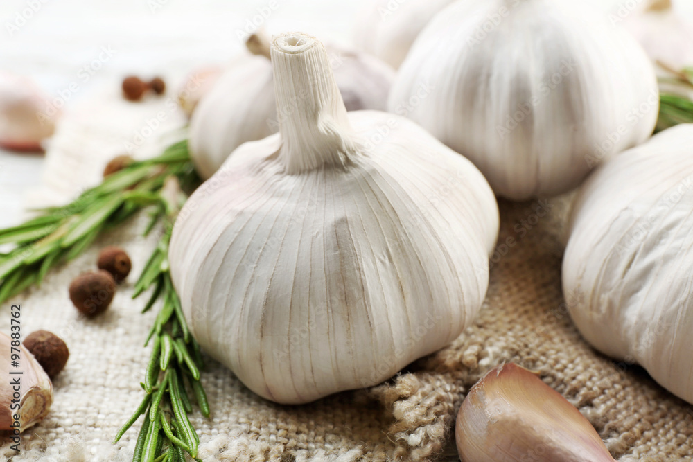 Composition of garlic and rosemary on sacking, close up Composition of garlic and rosemary on sacking, close up
