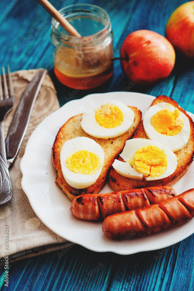 breakfast or lunch , apples and honey , toasted croutons of white bread with boiled egg and fried sausages on a wooden background
breakfast or lunch , apples and honey , toasted croutons of white bread with boiled egg and fried sausages on a wooden background