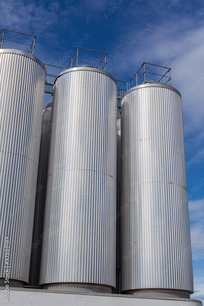 Giant industrial tanks on the bright blue sky