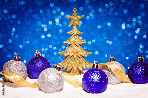 Golden Christmas tree on glitter blue background