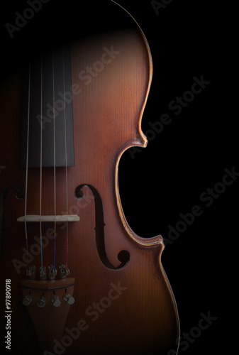 Old violin on black background.