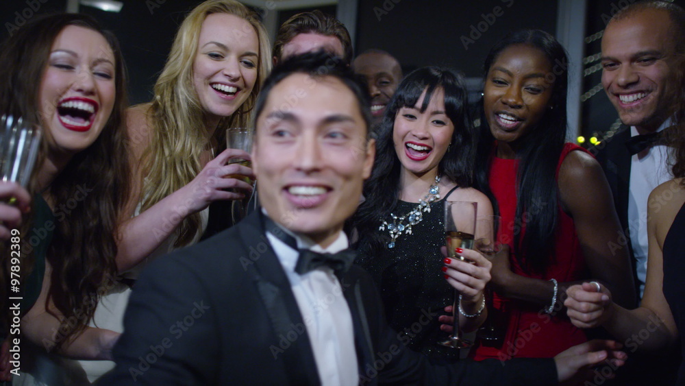 Happy attractive group of friends at a party pose to take a selfie together Happy attractive group of friends at a party pose to take a selfie together