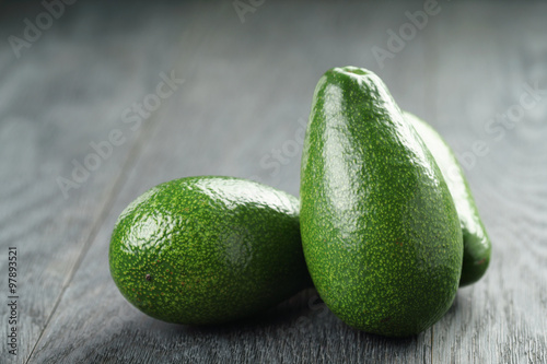 ripe green avocados on wood table