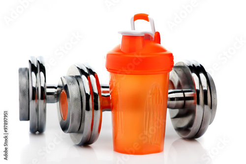 Whey protein shaker and dumbbells. Fitness and bodybuilding