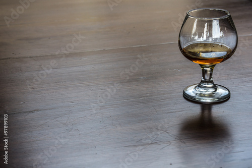 Принти на полотні Glass of aged tequila on a shiny wooden surface