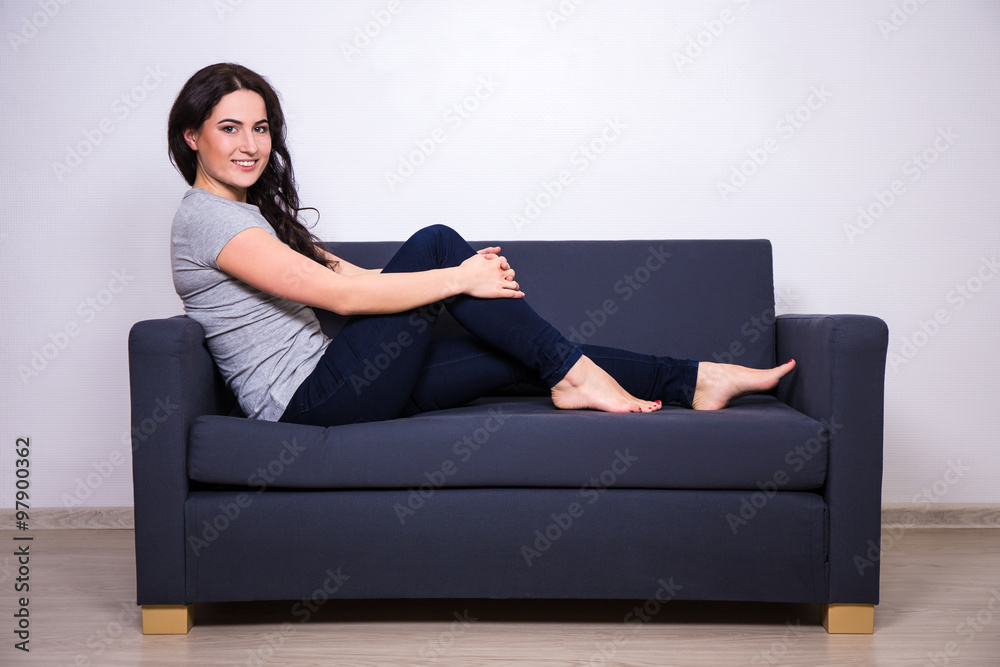 happy young beautiful woman sitting on sofa at home happy young beautiful woman sitting on sofa at home