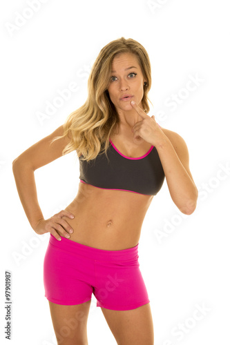 woman in fitness attire stand one hand on hip finger by mouth