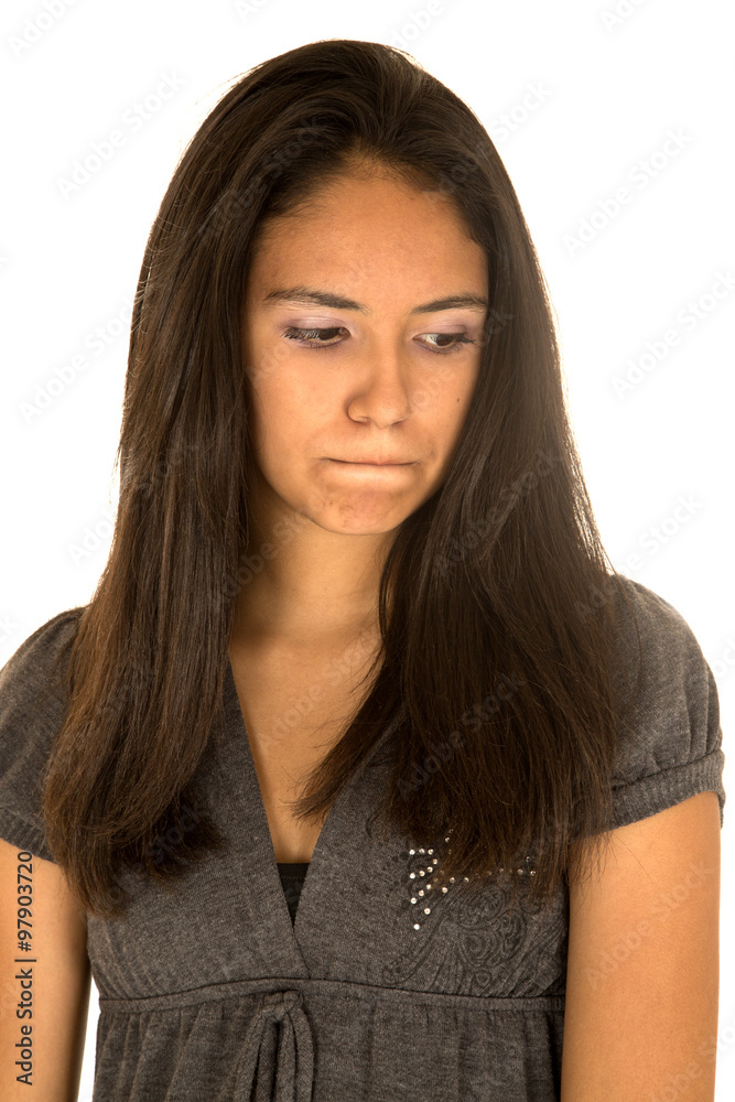 Cute Hispanic teen girl portrait looking down with pursed lips Cute Hispanic teen girl portrait looking down with pursed lips