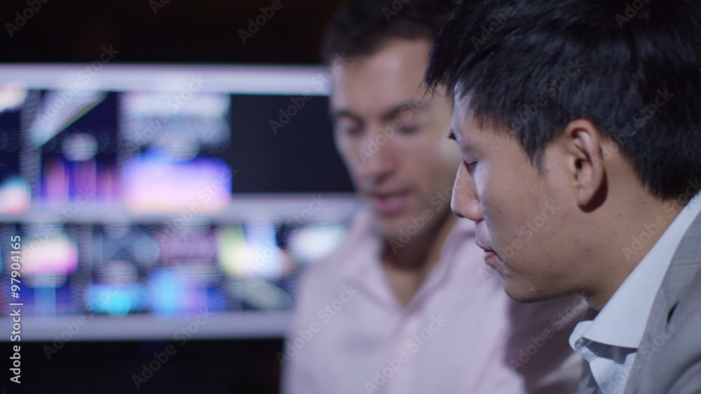 2 businessmen working together with technology in modern office 2 businessmen working together with technology in modern office