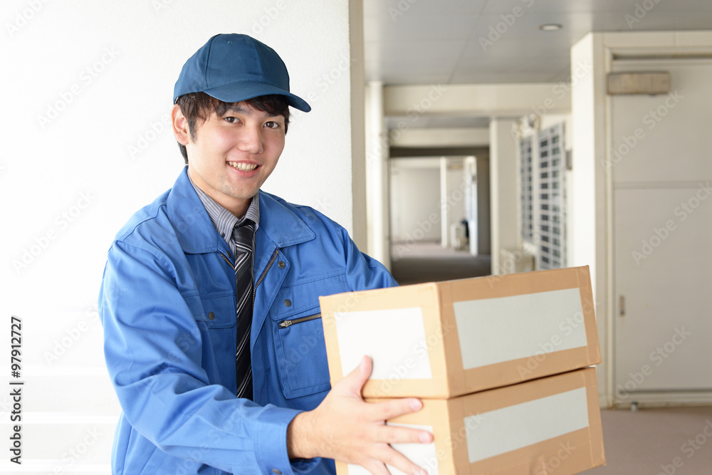 荷物を運ぶ笑顔の宅配人 荷物を運ぶ笑顔の宅配人