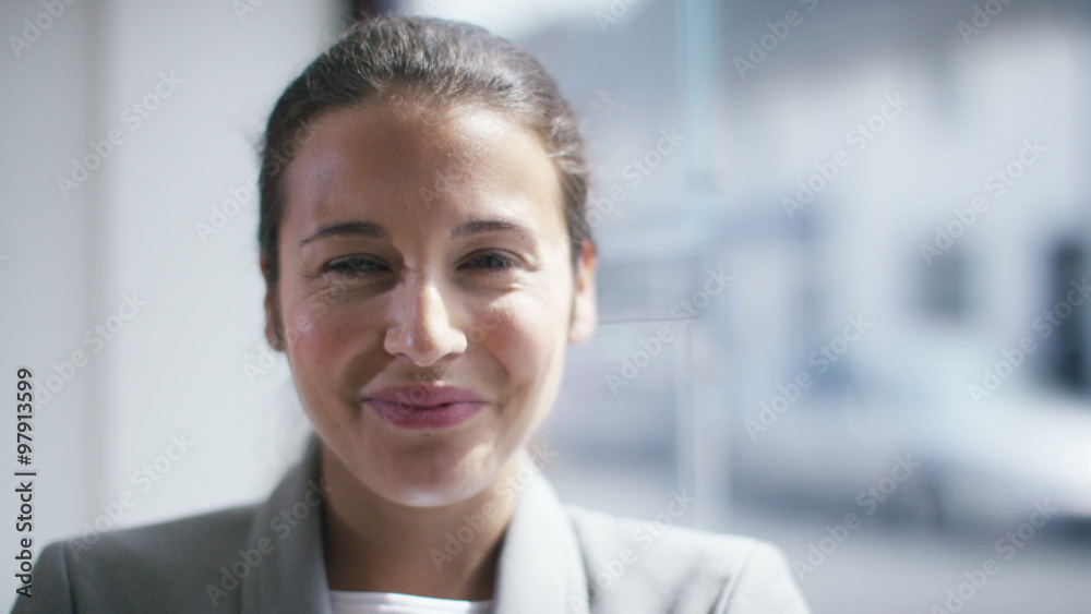 Portrait of young business woman smiling into camera Portrait of young business woman smiling into camera
