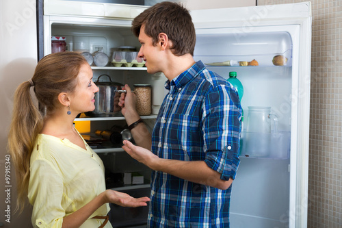 Young couple standing near fridge