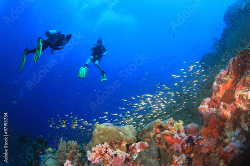 Scuba divers diving on coral reef with fish sea ocean underwater © Richard Carey