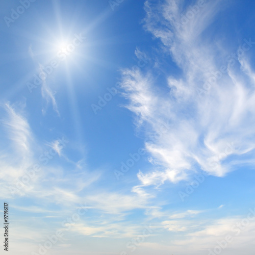 sun on blue sky with white clouds