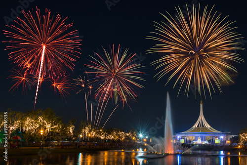 Beautiful building in public park on night sky with fountain foreground and fireworks backgrond. Suanluang Rama 9, Thailand.
