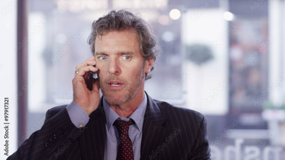  Angry businessman has a heated conversation with someone on the phone