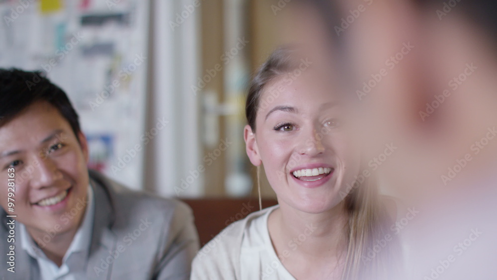 Attractive smiling business team talking together in office meeting Attractive smiling business team talking together in office meeting