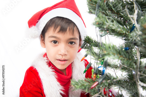 Little boy busy working on christmas tree for celebration