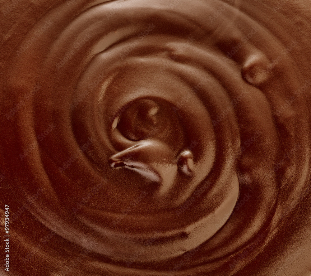 Melted dark chocolate flow, candy or chocolate preparation close-up as a background. Melted dark chocolate flow, candy or chocolate preparation close-up as a background.