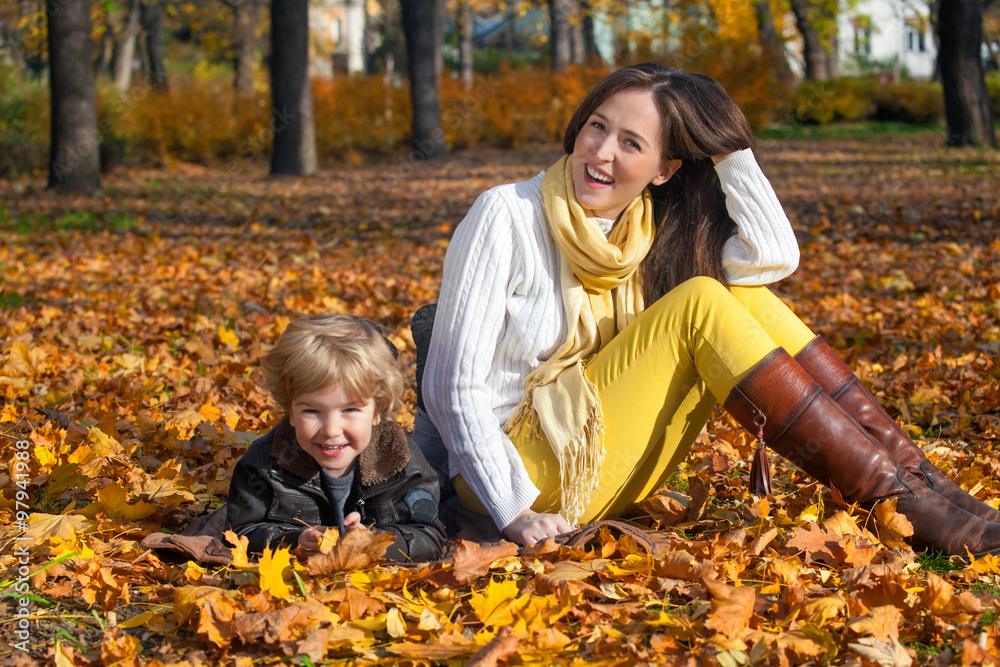 Portrait of happy mother and son relaxing in the park and enjoying in autumn season. Portrait of happy mother and son relaxing in the park and enjoying in autumn season.