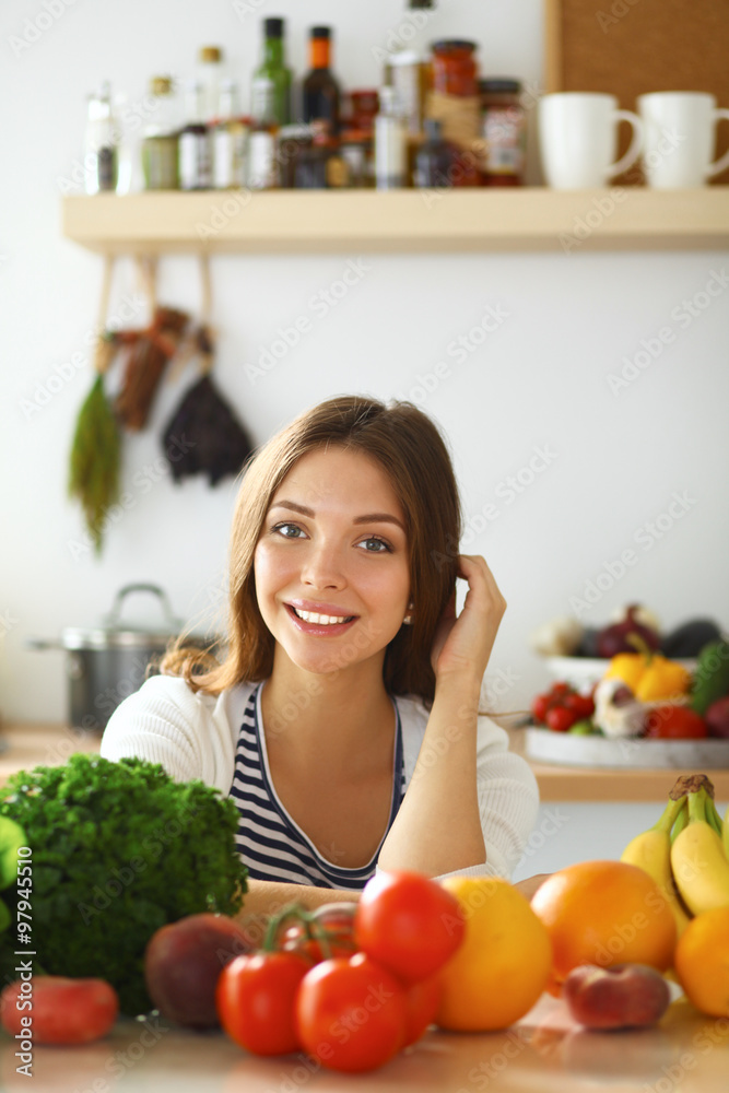 Young woman sitting near desk in the kitchen Young woman sitting near desk in the kitchen