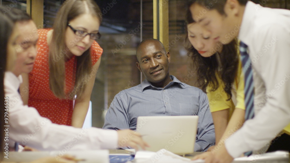 Mixed ethnicity business group in a meeting. The boss is watching his team. Mixed ethnicity business group in a meeting. The boss is watching his team.