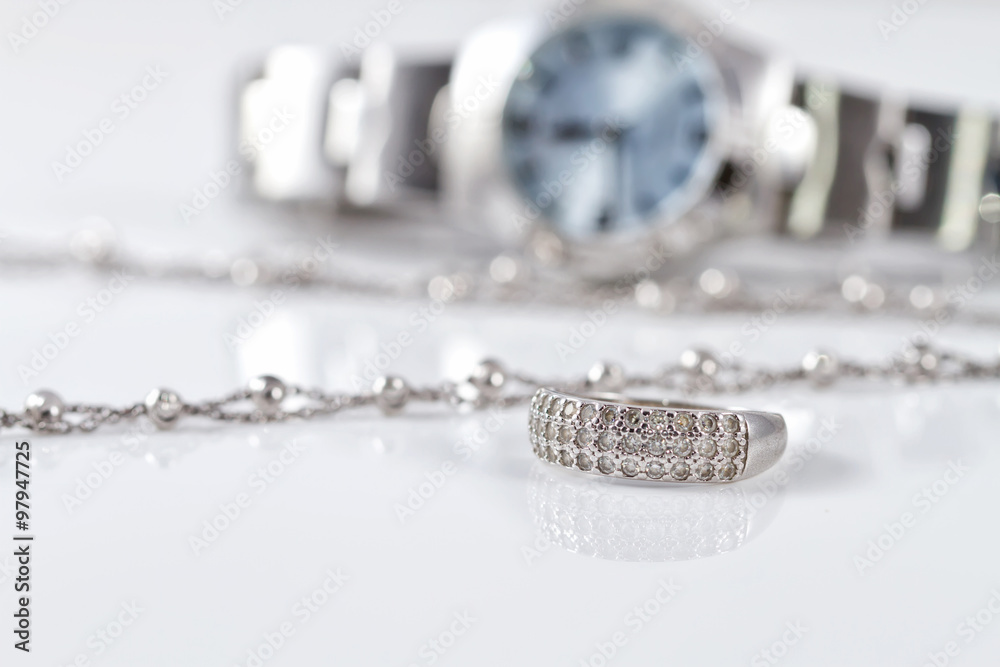 Silver ring and chain on the background of watches