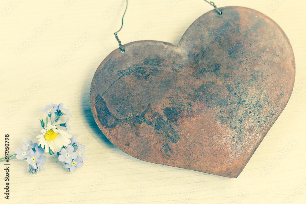 Alte Liebe rostet nicht ein rostiges Metallherz mit frischen Blümchen
