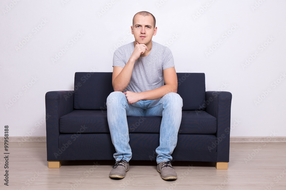 handsome man sitting on sofa at home