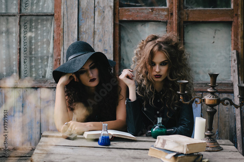 Photo Two vintage witches perform magic ritual